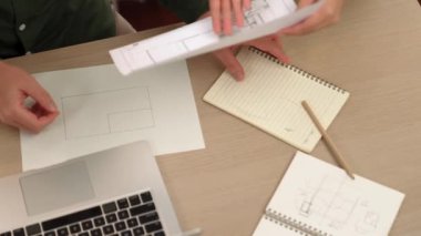 Akıllı mimar ve akıllı mühendisin dizüstü bilgisayarlı videosu mimarlık bürosundaki inşaat isabet planı hakkında tartışıyorlar. Eline odaklan. - Yakın çekim. Tanımlama.