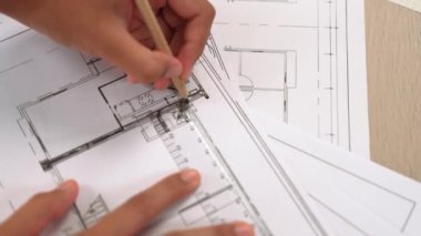 Ölçüm aracı ve kalem el kullanan akıllı mimar veya akıllı mühendisin videosu mimari ofisteki inşaat hatasızlığı için ayrıntılı bir tasarım hazırladı. Eline odaklan. - Yakın çekim. Tanımlama.