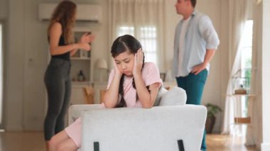 Sinirli ve mutsuz genç bir kız oturma odasında ebeveyninin tartışması yüzünden gerginliğin ortasında kanepede oturuyor. Sağlıksız ev hayatı ve travmatik çocukluk depresyona dönüşür.