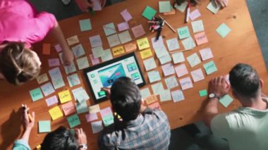 Tablet kablo prototipine bakarken, web tasarımı hakkında beyin fırtınası yapan ve planlayan programcıların tepeden tırnağa görüntüsü. Yetenekli müteahhit takımının dijital uygulamadan bahseden hava görüşü. Sempozyum.
