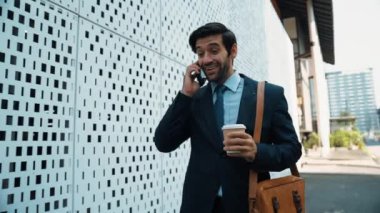İş adamı telefona cevap verir ve iş yatırımları hakkında konuşur. İş planı, pazarlama stratejisi ya da çalışma hakkında konuşmak için akıllı telefonla konuşurken sokakta yürüyen mutlu bir yönetici. Sevinçli..
