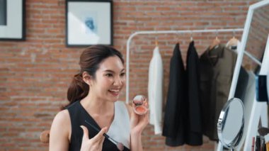 Kadın nüfuzlu kişi canlı yayın yapan video görüntülerini sosyal medya ya da blog üzerinden gözden geçiriyor. Kozmetik stüdyosu ışıklandırmalı mutlu genç kız çevrimiçi pazarlama oturumu yayını için..