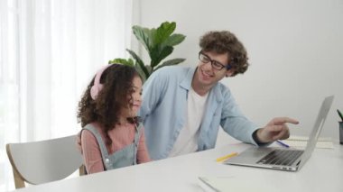 Amerikalı kız, kod yazmayı ve mühendislik yazmayı öğrenirken olumlu baba da birlikte çalışıyor ve programlama kodunu veya sistemini özenle göstermek için dizüstü bilgisayarına işaret ediyor. Pedagoji.