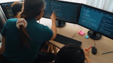 Yavaş çekim arkası yazılım geliştirici mühendisi bilgisayar programlama için birlikte çalışarak hata ayıklama kodunu çözüyor, ofiste monitörde karmaşık algoritmaları çözüyor. Filizlenen