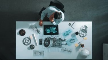 İş arkadaşı toplantıda yürürken akıllı müdürün oturduğu en tepeden aşağıya hava görüntüsü. Meslektaşı soru sorarken türbin motoru ya da elektronik jeneratöre bakan profesyonel bir mühendis. Hizalama.