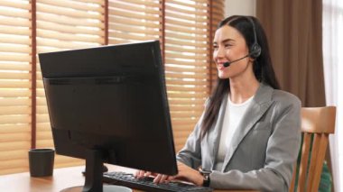 Kadın çağrı merkezi operatörü ya da müşteri hizmetleri çalışanı, müşteriye yardım etmek için kulaklıkla konuşurken çalışma alanı üzerinde çalışıyor. Profesyonel modern iş hizmeti. Blithe