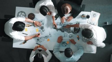 Mühendisin, toplantı masasındaki türbin motorunu ekipmanla gösteren üst düzey görüntüsü. Profesyonel proje yöneticisinin elektronik jeneratör sistemi hakkında konuştuğu ve tartıştığı hava görüntüsü. Hizalama.