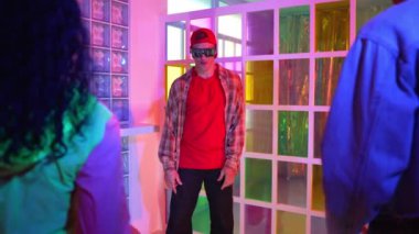 Kafkas dansçısı dans ederken çeşitli arkadaşları gece kulübünde neon ışıkta ayak seslerine bakıyor. Çoklu etnik kökenli hipsterin serbest stil müziğe geçişi ve mutlu bir adamın kameraya bakışıyla. Mutluluk.