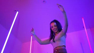 Latin dansçıların kameraya bakıp şehrin pop müziğiyle dans ettiği düşük açılı kamera. Profesyonel çekici hipster, mor veya neon ışıklı hip hop şarkısına geçiyor. Şık bir kumaş. Mutluluk.