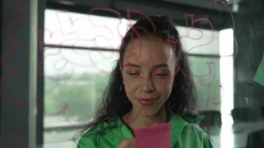 Genç İspanyol çalışanlar renkli yapışkan notlar yazıyorlar. Akıllı iş kadını pazarlama fikrini, beyin fırtınası stratejisini, iş planını paylaşıyor. Proje yöneticisi zihin haritası çiziyor. - Yakın çekim. Yönlendirici.