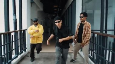 Modern koridor alışveriş merkezinde çok kültürlü hipster grubu yürüyüp sokak dansı yapıyor. Profesyonel aktif sokak dansçısı hip-hop müziğine adım atıyor. Açık hava sporu 2024 hiphop..