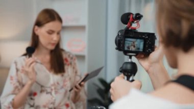Etkilenen iki ortak canlı yayında video görüntülerini çekiyor makyaj malzemesi prim sosyal medya veya blog. Kozmetik stüdyosu ışıklandırmalı mutlu genç kız çevrimiçi pazarlama oturumu yayını için..