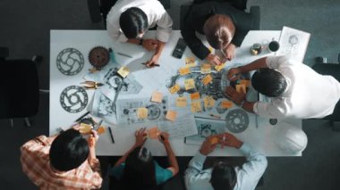 Üstten görünüşlü akıllı mühendis ekibi metal teçhizatlı, hesap makineli, yapışkan notlu türbin motor yapısı hakkında konuşuyor. Bir grup teknisyen toplantıda not alıyor. Hizalama.