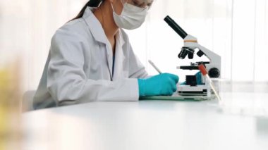 Laboratuvar kimya araştırmacısı mikroskop kullanarak yeni ilaç ya da tedavi geliştirir. Laboratuvar mikrobiyoloji ekipmanları ile bilimsel uzmanlık ile sağlık hizmetlerinin teknolojik gelişimi. Ağır çekim. Katı.