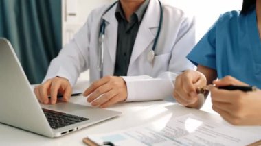 Hastane masasında birlikte çalışan ve tıbbi tedavi planlayan çeşitli profesyonel sağlık görevlileri. Takım çalışması başarılı hastalıklara ve hastalıklara yol açar. Ağır çekim. Katı.