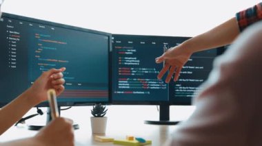 Yavaş çekim arkası yazılım geliştirici mühendisi bilgisayar programlama için birlikte çalışarak hata ayıklama kodunu çözüyor, ofiste monitörde karmaşık algoritmaları çözüyor. Filizlenen