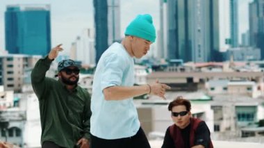 Çatıda çok kültürlü arkadaşlar varken profesyonel İspanyol break dansçısı B boy dansı. Genç modern dans grubu hip hop hareketi yapıyor. Tarz, moda, aksiyon. Açık hava sporu 2024 hiphop..