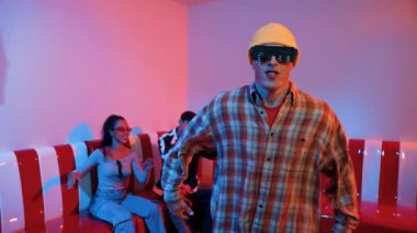 Kafkasyalı break dansçı çeşitli arkadaşlar birlikte dans ederken hareket eder. Çok kültürlü grup arkadaşını desteklemek ve cesaretlendirmek için el sallarken mutlu hipster hareketi. Mutluluk.