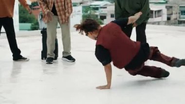 Çatıda çok kültürlü arkadaşlar varken profesyonel İspanyol break dansçısı B boy dansı. Genç modern dans grubu hip hop hareketi yapıyor. Tarz, moda, aksiyon. Açık hava sporu 2024 hiphop..