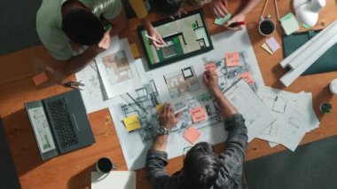 Pazarlama ekibi tasarım planlarken yöneticinin planlarını yukarıdan aşağıya incelemek. Mimar mühendisin birlikte çalıştığı, fikir paylaştığı ve proje planına not aldığı hava görüşü. Sempozyum.