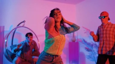 İspanyol hipster renkli kıyafetler giyer ve serbest stil müziğe el sallar. Profesyonel break dansçı neon ışıklarıyla ve modern stüdyo arkadaşlarıyla coşkuyla dans ediyor. Mutluluk.