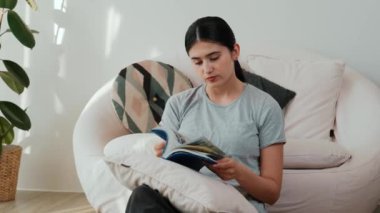 Kanepede oturan orta yaşlı bir kadın, sosyal ve teknolojik mesleki gelişmeler hakkında ders kitabı okur ya da zeki bir anne olmak için çocuk yetiştirir. Hayat boyu öğrenme konsepti. Uyumsuzluk.