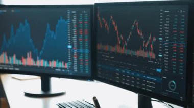 Menkul kıymetler borsası pazarlamasını inceleyen borsa yatırımcıları, zarar ve kazanç için mum bar fiyatlarını analiz eden monitörlere bakıyor. Filizlenen