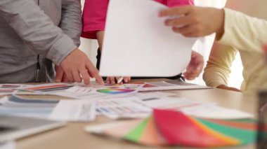 Grafik tasarımı için beyin fırtınası yapan ve renk seçimi yapan tasarımcı ekibinin yavaş çekim çekimi veya tasarım bürosunda krom danışmanlığı için danışmanlık isteyen bir müşteri. Değiştirilmiş