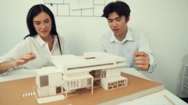 Profesyonel akıllı iş birliği mühendisi mühendis ekibi modern ofisteki ev yapısını planla kontrol ederken genç ve güzel proje yöneticisi not alıyor. Yaratıcı tasarım konsepti. Tertemiz...