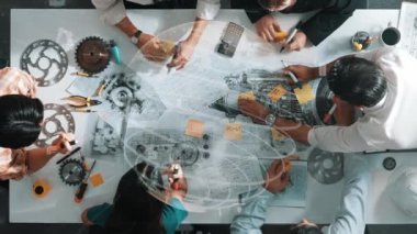 Profesyonel inşaat mühendisi ekibinin üst düzey görüşü ev modeline yapışkan notlar yazıp not tutarken iç mimar da finansal istatistik tablosunu tartışıyor. Hizalama.