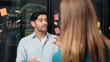 Akıllı yatırımcılara pazarlama fikri ya da finansal planı sunan profesyonel iş adamı. Yönetici yönetici paylaşıyor, konuşuyor, kooperatif iş arkadaşlarıyla birlikte çalışıyor. İş konsepti. İzleme