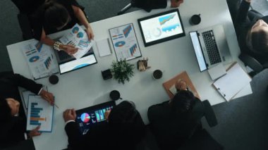 Akıllı iş adamlarının yukarıdan aşağıya görüşü yatırımcılara finansal grafiği açıklarken, iş adamları da toplantı masasında borsa yatırım grafiğini analiz ediyor. Çeşitli grup beyin fırtınası fikri. Müdürlük.