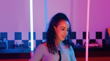 Stüdyoda mor ışıkla sokak dansı yapan İspanyol sokak dansçılarına yakın çekim. Profesyonel sanatçı şık kumaşla enerjik bir hareket sergiler. Çılgın, komik. Yarı vücut. Mutluluk.