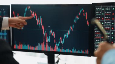 Hisse senedi borsası pazarlamasını analiz eden yavaş çekim şirketindeki yatırımcılar, kayıp için mum bar fiyatını analiz eden monitörlere bakıyor ve kazanç ve kâr elde ediyor. Filizlenen