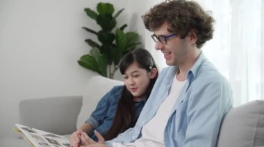 Beyaz bir baba ve tatlı bir kız kanepede otururken masal kitabı okuyorlar. Mutlu bir baba, sevimli bir Amerikan çocuğuna, birlikte zaman geçirirken hayal gücünün gelişmesi için hikaye anlatıyor. Pedagoji.