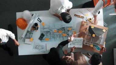 Becerikli mühendis ekibinin ev inşaatından bahsedişinin en alt görüntüsü. Mimar ya da tasarımcı grubunun planlar hakkında beyin fırtınası yapmak için tartışan ve yazan hava görüşü. Hizalama.