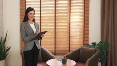 Mutlu ve gülümseyen kadın psikolog psikiyatri ofisinde ya da terapi odasında pano tutuyor. Arkadaş canlısı ve profesyonel ruh sağlığı danışmanı ya da terapisti. Blithe
