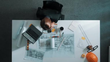 Yapışkan notlar ve hesap makinesiyle bina inşaatı için dizüstü bilgisayar üzerinde çalışırken çalışan mimar mühendisi. Akıllı yönetici plan hesaplamak için hesap makinesi kullanıyor ve çalışıyor. Hizalama.