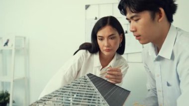 Ev inşaatını işaret edip tartışırken mimari teçhizat kullanarak birlikte çalışan profesyonel mühendis ekibinin yakınlaşması. Yaratıcı karar ve takım çalışması konsepti. Tertemiz..