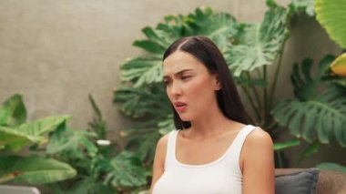 Stresli kadın, yeşillik arka planında internet üzerinden çalışırken yorgun ve hayal kırıklığına uğramış hissediyor. Bunaltıcı ve zorlu uzak çalışma görevleri. Blithe