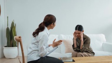 Psikologla ruh sağlığı terapisi gören üzgün travma sonrası stres bozukluğu olan bir kadın. Yaşam sonrası depresyon veya keder. Hayal kırıklığına uğramış genç bir kadın klinikteki duygular hakkında Vivancy psikoloğuyla konuşuyor.