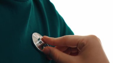 Hasta klinikte ya da hastane ofisinde doktor randevusuna gidiyor. Hastaların risk faktörünü tespit etmek için nabzını ölçmek için steteskopla doktor muayenesi ve teşhis semptomları. Ağır çekim. Katı.