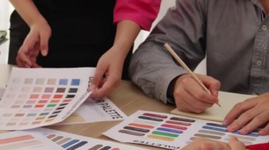 Tasarımcı ekibinin beyin fırtınası yaptığı ve grafik tasarımı için renk seçimi yaptığı el kapanışı ya da tasarım bürosunda krom danışmanlığı için danışmanlık isteyen bir müşteri. Değiştirilmiş