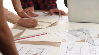 Mimarlık ve güvenlik mühendisi, modern ofiste dizüstü bilgisayarda mimari belge ve ahşap blokla sergilenen planlar hakkında tartıştı. - Yakın çekim. Tanımlama.