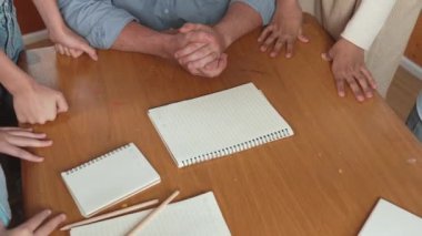 Kafkas öğretmeni ve çeşitli çocuklar başarılı bir projeyi kutlamak için el ele tutuşurken kağıt masaya saçıldı. Aşkı, şirketi, takım çalışmasını, birlikteliği ve birliği temsil et. Öğretim