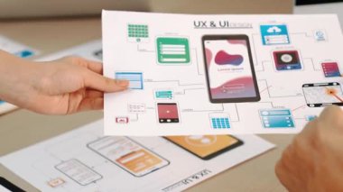 Mobil uygulama için kullanıcı arayüzü prototipini ofis çalışanlarına sunan harika bir şirket çalışanı. UX UI tasarımcısı iş arkadaşına kağıt üzerinde tasarım hakkında övgüde bulundu. Sinerjik