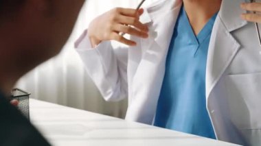 Hasta klinikte ya da hastane ofisinde doktor randevusuna gidiyor. Hastaların nabzını steteskopla kontrol edip risk faktörünü belirleyen doktor semptomları inceliyor. Panorama. Katı.