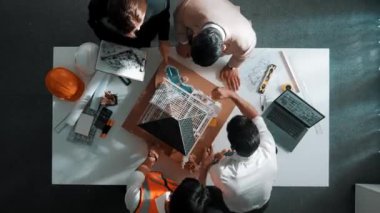 Akıllı mimar mühendis ekibinin ev modelini incelemesi ve proje yöneticisinin bina inşaatı hakkında sorular sorması. Çeşitli mühendislerden oluşan bir grup birlikte çalışıyor. Hizalama.