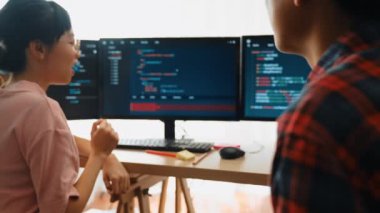 Yavaş çekim arkası yazılım geliştirici mühendisi bilgisayar programlama için birlikte çalışarak hata ayıklama kodunu çözüyor, ofiste monitörde karmaşık algoritmaları çözüyor. Filizlenen