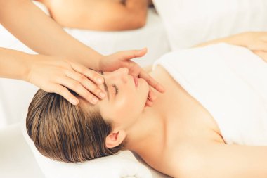 Kafkasyalı çift stres önleyici kafa masajının keyfini çıkarıyor ve lüks otellerde ya da otel spa salonlarında gündüz kaplıcalarında yüz güzelliği eğlencelerini şımartıyor. Sessiz.